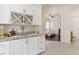 Wet bar with granite countertops, white cabinets, wine rack, and access to bathroom and bedroom at 5418 Sandy Hill Ln, Lady Lake, FL 32159