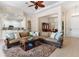 Comfortable living room with a plush sofa, a ceiling fan, and an open view to the kitchen and dining areas at 5418 Sandy Hill Ln, Lady Lake, FL 32159