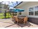 Covered patio features a wooden dining table with seating for ten under a blue umbrella at 5418 Sandy Hill Ln, Lady Lake, FL 32159