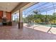 Outdoor kitchen with brick floors and pillars, a bar, and a pool at 5418 Sandy Hill Ln, Lady Lake, FL 32159