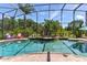Pool with brick floors and a hot tub with a water feature and landscaping at 5418 Sandy Hill Ln, Lady Lake, FL 32159