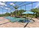 Stunning screened pool with a spa and brick surround, complemented by tropical landscaping and outdoor seating at 5418 Sandy Hill Ln, Lady Lake, FL 32159