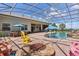 Enjoy the Florida sunshine in the screened-in pool area with stone fire pit and ample seating at 5418 Sandy Hill Ln, Lady Lake, FL 32159
