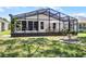 Back exterior view of screened in patio overlooking landscaped backyard at 5507 Laver St, Leesburg, FL 34748