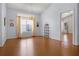 Dining room with wood floors, a large window with curtains, a hanging chandelier, and doorway to the kitchen at 5507 Laver St, Leesburg, FL 34748