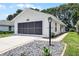 Exterior of a one-story home featuring a screened-in garage, a small lightpost, and rock features at 5507 Laver St, Leesburg, FL 34748
