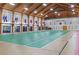 Large gymnasium with wood floors, basketball hoops, and decorative flags at 5507 Laver St, Leesburg, FL 34748