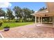 Expansive brick patio leads to a covered outdoor area, perfect for entertaining and enjoying the serene backyard at 5729 Bible Camp Rd, Groveland, FL 34736