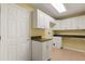 Bright laundry room featuring white cabinets and granite countertops, ready for efficient home management at 5729 Bible Camp Rd, Groveland, FL 34736