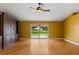 Living room with gleaming wood floors, natural light, and sliding doors offering a view of the backyard at 5729 Bible Camp Rd, Groveland, FL 34736