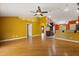 Open-concept living area with hardwood floors and warm, inviting colors flowing into the kitchen area at 5729 Bible Camp Rd, Groveland, FL 34736