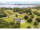Stunning aerial view of a modern home on a large lot with a pool, surrounded by lush greenery and lake views at 6031 Dora Dr, Mount Dora, FL 32757