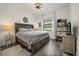 Charming bedroom showcasing wood floors, natural light, and a comfortable queen bed, perfect for relaxation at 6031 Dora Dr, Mount Dora, FL 32757