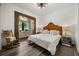 Cozy bedroom with a queen bed, rocking chair, wood floors, and soft lighting, creating a peaceful ambiance at 6031 Dora Dr, Mount Dora, FL 32757