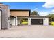 Modern home featuring a gray brick driveway, attached garage, porte-cochere and wood and stone accents at 6031 Dora Dr, Mount Dora, FL 32757