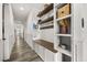 Hallway with built-in shelving, coat hooks, bench seating, and light wood floors at 6031 Dora Dr, Mount Dora, FL 32757