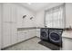 Laundry room with a countertop, utility sink, cabinetry, and modern washer and dryer at 6031 Dora Dr, Mount Dora, FL 32757