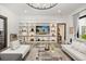 Stylish living room featuring built-in shelving, a large TV, comfortable seating, and modern decor at 6031 Dora Dr, Mount Dora, FL 32757