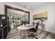 Home office with glass doors leading to living room, light wood flooring, and white accents at 6031 Dora Dr, Mount Dora, FL 32757