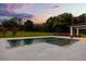 Backyard with in-ground pool, spa, mature trees and landscaping at sunset at 6031 Dora Dr, Mount Dora, FL 32757
