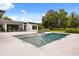 Backyard with modern pool, lounge chairs, patio, and extensive landscaping and mature trees at 6031 Dora Dr, Mount Dora, FL 32757
