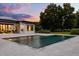 Backyard with a geometric pool and lush surroundings under a vibrant sunset sky at 6031 Dora Dr, Mount Dora, FL 32757