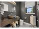 Stylish powder room with dark walls, vessel sink, unique wooden vanity, and tiled floors at 6031 Dora Dr, Mount Dora, FL 32757