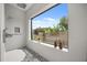 Bright shower with a large window showcasing lush greenery and blue sky, complemented by stylish tile work at 6031 Dora Dr, Mount Dora, FL 32757