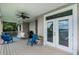 View of a covered back porch with outdoor seating and water view in background at 6136 Lake Emma Rd, Groveland, FL 34736
