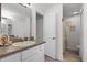 Bright bathroom featuring a vanity with a neutral countertop and an open doorway to the shower at 6136 Lake Emma Rd, Groveland, FL 34736