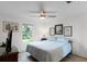 The bedroom is cozy with hard wood floors, a ceiling fan, backyard views, and casual decor at 6136 Lake Emma Rd, Groveland, FL 34736