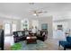 Bright and spacious living room features wood floors, ceiling fan, and comfortable leather furniture at 6136 Lake Emma Rd, Groveland, FL 34736