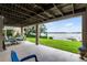 Covered patio featuring a dining table and outdoor seating area with a view of the lush backyard and lake at 6136 Lake Emma Rd, Groveland, FL 34736