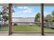 View of a lake from a covered back porch with white railing and green grass in foreground at 6136 Lake Emma Rd, Groveland, FL 34736