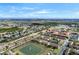 Expansive aerial view of a residential community with townhomes, greenery, and scenic pond with fountain at 624 Terra Lago St, Davenport, FL 33897