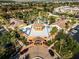 Aerial view of the Regal Palms Clubhouse with elegant entrance, vibrant landscaping, and circular driveway at 624 Terra Lago St, Davenport, FL 33897