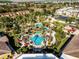 Aerial view of the vibrant community pool area featuring a lazy river, slides, and lush landscaping at 624 Terra Lago St, Davenport, FL 33897