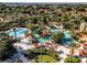 Aerial image of the large community pool, lazy river, and deck chairs surrounded by palm trees at 624 Terra Lago St, Davenport, FL 33897