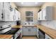 Bright kitchen with white cabinets, butcher block countertops, undermount sink, and stainless steel appliances at 624 Terra Lago St, Davenport, FL 33897