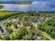 An aerial view showcases a property amid verdant trees, with views of a stunning lake at 6731 Lake Griffin Rd, Lady Lake, FL 32159