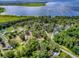 An aerial view showcases a home amid verdant trees, with views of a stunning lake at 6731 Lake Griffin Rd, Lady Lake, FL 32159