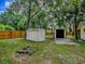 The backyard features two sheds, lush green grass, and a wooden privacy fence at 6731 Lake Griffin Rd, Lady Lake, FL 32159