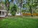 This backyard features lush grass, mature trees, a fence, and a storage shed at 6731 Lake Griffin Rd, Lady Lake, FL 32159