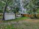 This backyard offers two sheds, lush green grass, and a wooden fence for privacy at 6731 Lake Griffin Rd, Lady Lake, FL 32159