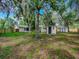 Spacious backyard features lush landscaping, sheds, and a wooden fence for added privacy at 6731 Lake Griffin Rd, Lady Lake, FL 32159