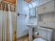 This bathroom offers a pedestal sink, toilet, mirror, and shower with vintage decor at 6731 Lake Griffin Rd, Lady Lake, FL 32159