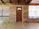Inviting entryway with brick walls, wood accents, and a door with glass detailing, offering a warm welcome at 6731 Lake Griffin Rd, Lady Lake, FL 32159