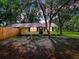Charming single-story home with black door, black shutters and surrounded by mature trees at 6731 Lake Griffin Rd, Lady Lake, FL 32159