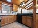 Kitchen featuring wood cabinets, black countertops and appliances, and tile backsplash at 6731 Lake Griffin Rd, Lady Lake, FL 32159