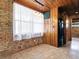 Cozy kitchenette with brick accents, wooden ceiling and cabinets, and a modern black refrigerator at 6731 Lake Griffin Rd, Lady Lake, FL 32159